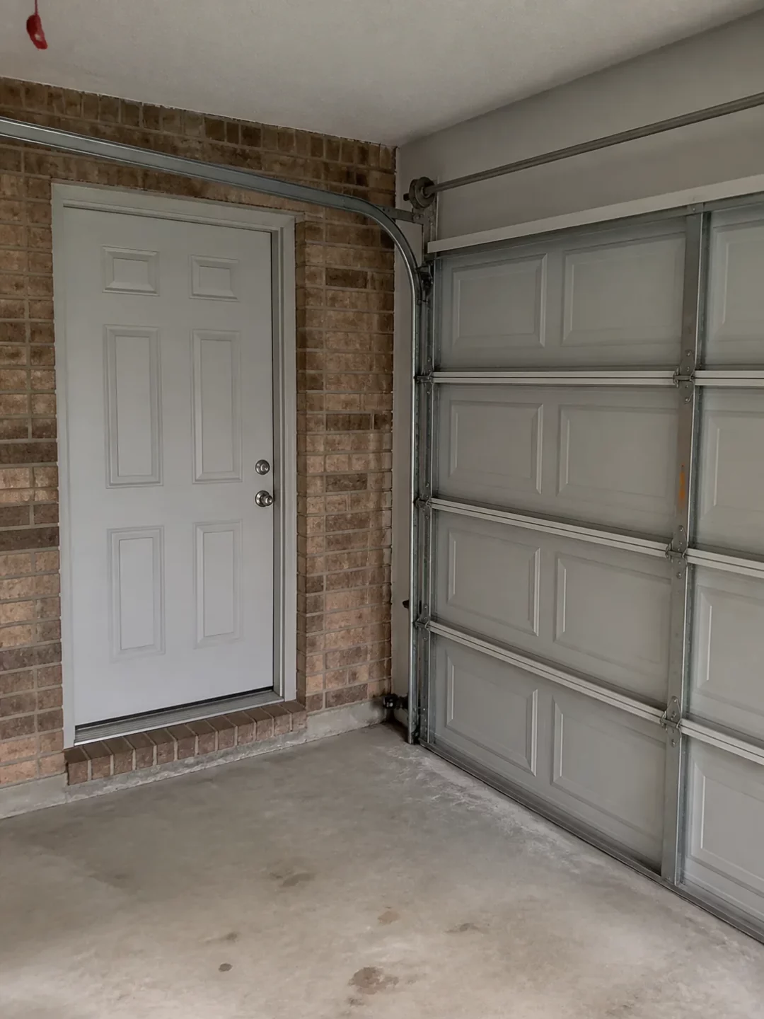 Pedestrian entry door beside a sectional garage door